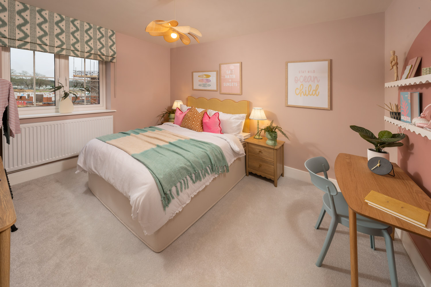 Pink and green pastel coloured bedroom with bedside table with lamp and made up bed. window to the rear